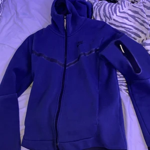 Blå Nike tech fleece - En blå Nike tech fleece tracksuit i storlek XS på koftan och M på byxorna  Säljer bara hela dressen inte separat Koftan sitter som en vanlig S och byxorna sitter också Som S