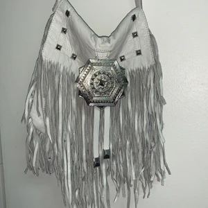 Vit River Island väska med fransar - Vit väska i äkta läder med 2 stora fickor från märket River Island väskan är ungefär 30cm lång och 20 cm bred, pris kan diskuteras🤍