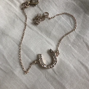 Armband  - Ett silvrigt armband med en hästsko på 