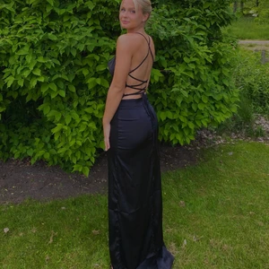 Svart klänning - En svart klänning i satin från Nelly. Köpt för bara någon månad sedan och använd en gång. Klänningen är i fint skick. ( ordinarie pris är 600kr) Köpare står för frakt