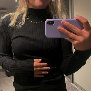 Svart ribbad polotröja  - Säljer denna svarta ribbade polotröjan ifrån Hm. Säljer den pågrund ut av att den aldrig har använts och är därför som helt ny i skicket. Den är stretchig och formar sig bra efter kroppen.  Köptes för 149kr säljer för 59kr.