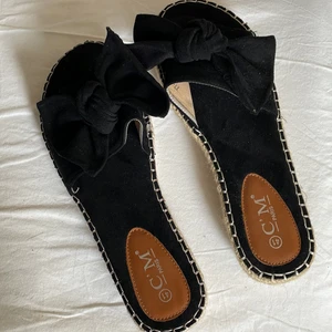 Oanvända svarta sandaler - Oanvända svarta sandaler med rosetter. Säljer bruna också. Storlek 41 men passar mig med 40. Frakt tillkommer