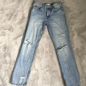Zara blå mid Rise jeans med slitningar  - Jättefina jeans från zara med slitningar👖Varit helt slutsålda ett tag och vet inte längre om de säljer dem. Använda cirka en gång men satt lite för tajt vid låren vilket är anledningen till att jag säljer dem tyvär💞 Köpte för 399kr