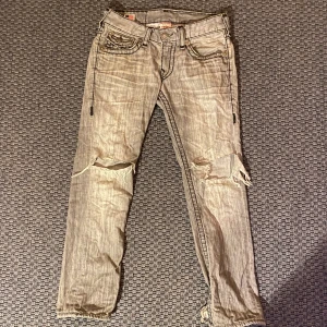 True Religion jeans - Säljer mina trueys då jag köpt nya! Dessa byxor är otroligt feta och schyssta och sitter väldigt bekvämt. Dom är storlek 29 men känns och sitter dom 30 eller 31, så anta inte att dom är för små!!! Den enda ”skadan” som finns är slitage och hål vid knäna men enligt mig har det bara tillfört ännu snyggare look. Skriv vid frågor mm!