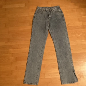 Blåa jeans. - Byxorna är alldrig använda och har bara prövatas, dem har ett slitt längs ner på båda benen.
