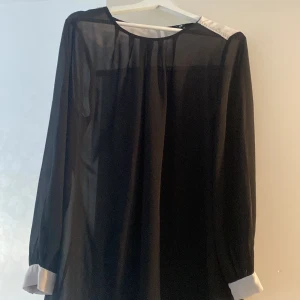 Blus - En svar lite genomskinlig blus fast fin.