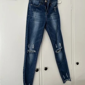 Mörkblåa Jeans. - Mörkblåa lågmidjade jeans med hål på knäna