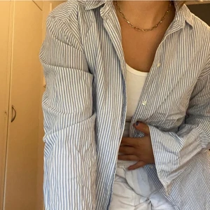 Blå vit randig skjorta - Säljer denna fina och sommriga skjortan! Den är blå vit randig med vita knappar! Bilderna är lånade från tidigare ägare! Kontakta mig vid intresse🦋🦋