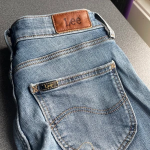Blå jeans från Lee - Ljusblåa jeans från märket Lee, med en slit samt några slitningar. Pris kan diskuteras. Skriv för fler bilder. 