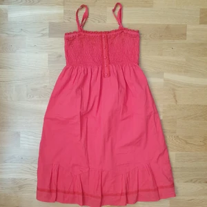 Sommarklänning  - Hallonröd sommarklänning med reglerbara axelband stl 38 men mer som 36. 77 cm lång ( axelband ej inräknat )  Använd en gång.  