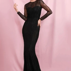 Lång svart balklänning - Oanvänd Lång svart balklänning med små svarta glittriga paljetter på hela vägen ner. Långärmad. Dragkedja bak. Passar även storlek S