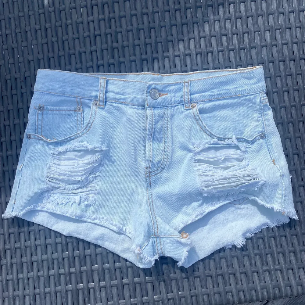 Low waist jeansshorts med ljusblå tvätt, slitningar på båda sidor. Strl.S😇 Från Bikbok, nästan aldrig använda💞💞Mötes upp eller frak på 45kr eller 66kr spårbar frakt. Shorts.