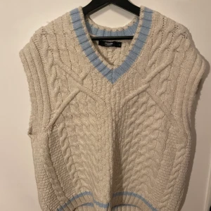 Stickad väst från Jaded - Ljus stickad väst från Jaded med ljusblå detaljer. Bra skick och i storlek L