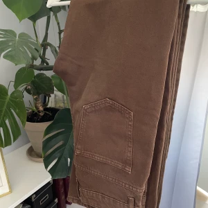 Raka jeans - Raka jeans i brun färg. Tajt över rumpa/lår. Använd några enstaka tillfällen. Höga i midjan.