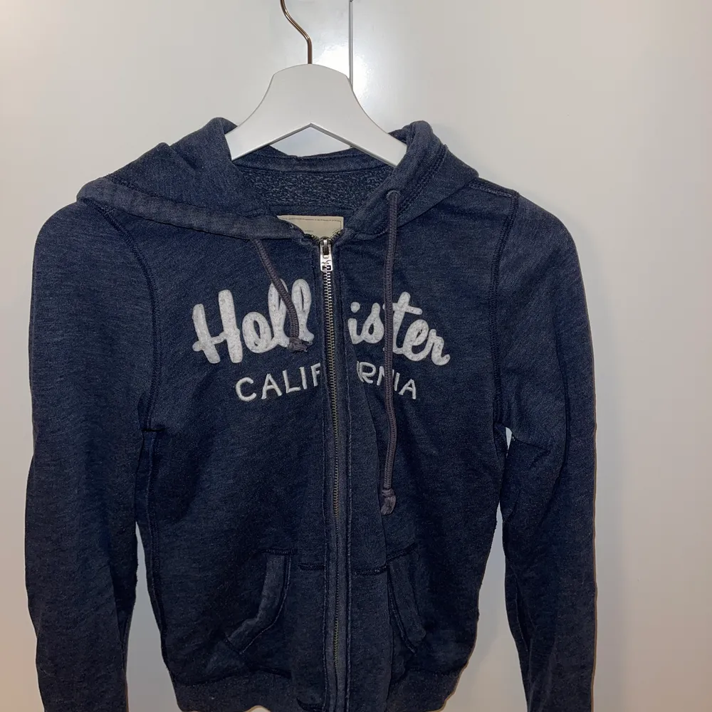 Mörkblå Hollister hoodie med kedja. I storlek small. Kan självklart skicka fler bilder om det önskas!. Hoodies.