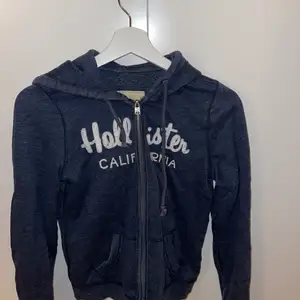 Mörkblå Hollister hoodie med kedja. I storlek small. Kan självklart skicka fler bilder om det önskas!