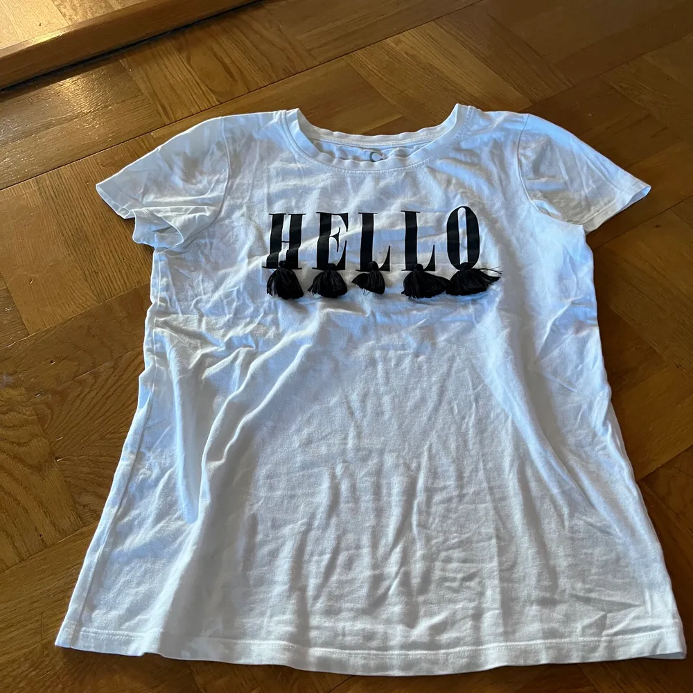 T-shirt från Cubus med ”Hello” tryck och tofsar . T-shirts.