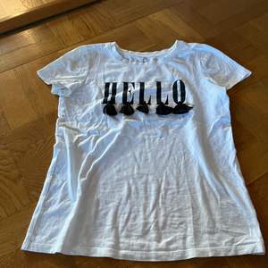 T-shirt från Cubus med ”Hello” tryck och tofsar 