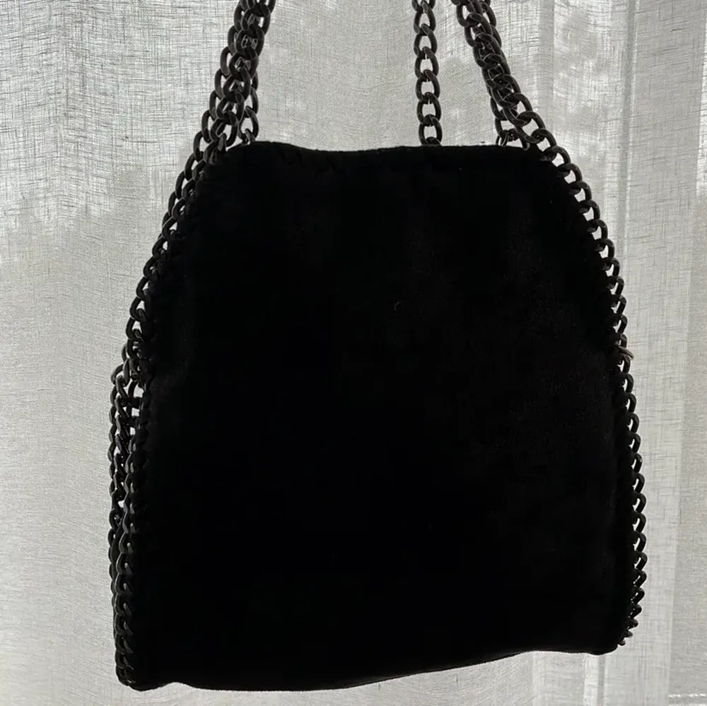 En svart väska med kedjor! Två band finns till, en kortare och en lite längre👍🏻. Väskor.