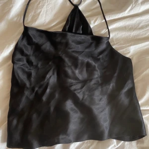 Satintopp med öppenrygg - Jättesnygg svart satin topp med en öppen rygg. Inga tecken på användning