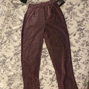 Byxor  - Glittriga byxor i storlek Xs från Nelly.