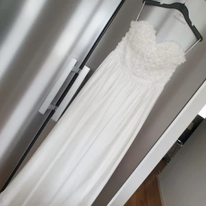 Vit lång vacker klänning - Vacker  fodrad axellbandlös hellång klänning i vitt med  överdel vita rosor från Gina Tricot Storl 38 Polyester Handtvätt Skick : som ny , endast använd vid ett tillfälle 300 kr Hämtas Brandbergen eller skickas mot portoavgift