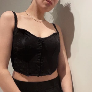 Korsettop  - Svart korsettop med sammetsblommor