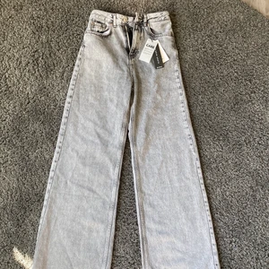 Grå wideleg jeans - Säljer dessa helt nya wideleg jeans pågrund av för stor i storlek för mig, helt oanvända med alla lappar kvar, nypris betalade jag 399kr