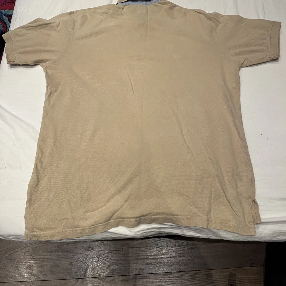 Det är en beige Tommy hilfiger piké tröja som är i storleken L 6/6. Är i bra skick och har inte några märken eller missfärgningar.. Skjortor.