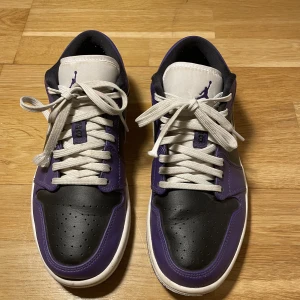 Jordan 1 Low  - Ett par Air Jordan 1 low court purple skor storlek 41. Skorna är i bra skick bara använda ett fåtal gånger inga fläckar eller skador på skorna. Nypris 1200kr. Vid flera frågor om skorna tveka inte att kontakta!