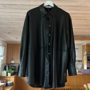 Skjorta i fakeläder MANGO - Svart skjorta från Mango i fake läder. Säljer pga att den inte används längre. Storlek S💗💗priset kan diskuteras!