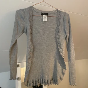 Jätte söt grå kofta från rosemund  - Knappt använd.   (Saknar tre knappar)  Men man kan ändå stänga koftan och annars är den jättefin öppen. 