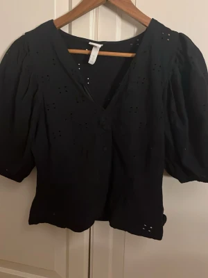 Svart blus med knappar - Säljer denna svarta blus ifrån hm som inte går att köpa längre i stl m men passar s