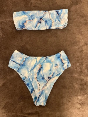 Blå marmor bikini  - En snygg marmor bikini i olika nyanser av blå. Toppen är off shoulder. Ni ser måtten på bilderna, hör av er om ni undrar något mer 🫶