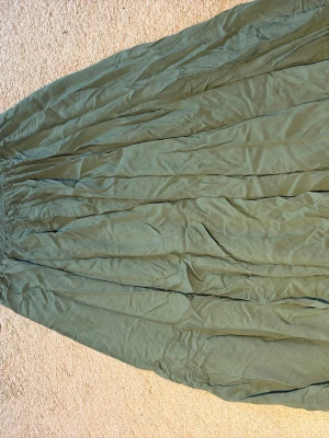 Grön långkjol/byxor i luftig bomull - Säljer en flowy grön långkjol/byxor med resår i midjan. Kjolen är gjord i ett tunt och luftigt bomullstyg som ger ett avslappnat intryck. Perfekt för dig som gillar en bohemisk och chill stil.