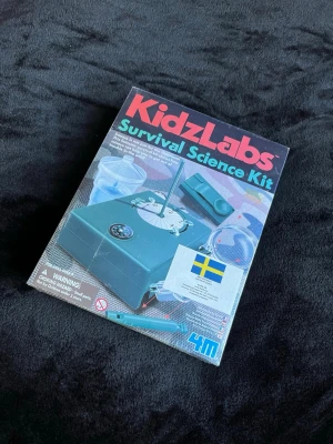 KidzLabs Survival Science Kit - Upptäck överlevnadsvetenskap med KidzLabs Survival Science Kit! Innehåller flera experiment och verktyg som kompass, vattenfilter, solur, mikroskop och morsekodslampa. Perfekt för unga upptäckare som gillar äventyr och naturvetenskap. Både för barn och vuxna! Helt nytt och plasten är kvar! Säljer liknande grejer och mer, har även bundle rabatter! 