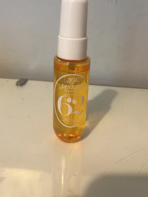 Sol de Janeiro 62 Parfym Mist - Sol de Janeiro 62 är en parfym mist i en genomskinlig orange plastflaska med vit spraykork. Doften har inslag av pistage, salt karamell och vanilj. Perfekt för dig som gillar söta och fräscha dofter med en tropisk känsla.