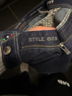 Mörkblå jeans Jacob Cohen Style 625 - Säljer ett par snygga mörkblå jeans från Jacob Cohen, modell Style 625. Klassisk femficksdesign med detaljer i italienska färger och dragkedja framtill. Jeansen är tillverkade i högkvalitativt denim och har en stilren look som passar till det mesta.