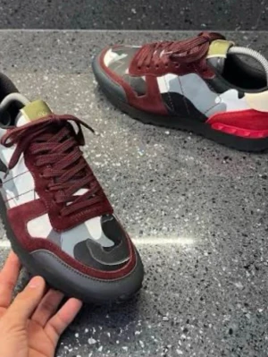 Valentino rockrunners vinrött - Snygga sneakers från Valentino med camomönster i svart, vitt och grått samt detaljer i vinröd mocka. Skorna har svarta sulor och vinröda skosnören. Perfekt för dig som vill sticka ut med en unik och trendig look. St 41