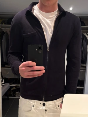 J.lindeberg tröja - Mörkblå tröja från J.lindeberg. 100% merinoull och två dragkedjor. Inga deflekter eller noppror.