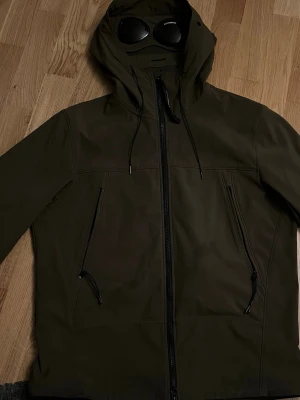 jacka från C.P. Company - Säljer en olivgrön vindjacka från C.P. Company med goggles. Den är äkta. Kom gärna privat ifall du har några fler frågor! ÄKTA 