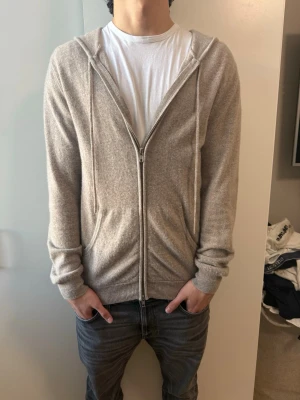 John Henric beige kashmir zip up - Säljer en beige zip up med dragkedja och huva från John Henric och den är 100% gjort av Kashmir, storlek M, nyskick inga defekter som ny. Använd max 4-5 gånger, nypris-3000kr mitt pris-1400kr, pris kan diskuteras vid snabb affär!