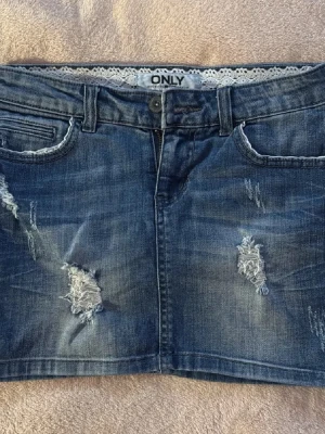 Jeanskjol med lace och slitningar - Såå cool vintage lågmidjad mini jeanskjol från ONLY med snygga slitna detaljer och lace detalj (se bilderna) 