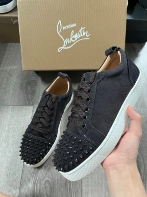 Svarta Louboutin sneakers med nitar - Snygga svarta sneakers från Christian Louboutin med matta nitar på tån och klassisk röd sula🙌🏻 Storlek 42 i fint skick😇 Hör av er vid funderingar samt snabbaffär🤗
