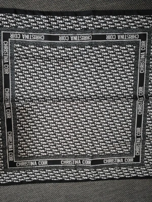 Svartvit scarf från Christina Coir - Säljer en silk svartvit scarf från Christina Coir med ett tätt mönster av små vita elefanter på svart botten. Runt kanten finns en svart ram med varumärkets namn i vitt. Perfekt accessoar för att lyfta din outfit.