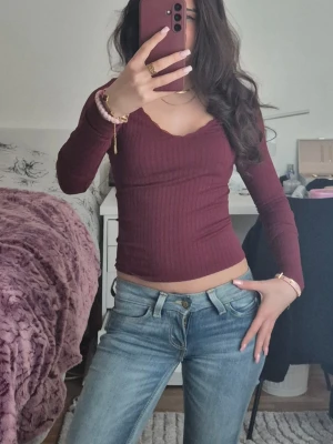 Vinröd ribbad långärmad topp i xs - Snygg vinröd ribbad topp med lång ärm och v-ringad hals. Figurnära passform men väldigt stretchig i material och perfekt att styla med jeans eller kjol. Mjuk och stretchig känsla, passar dig som gillar en enkel men trendig look. Skriv järna om prisförslag eller funderingar ❤️🫶