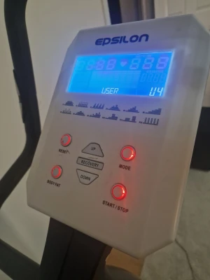 Epsilon motionscykel med display - Säljer en vit och svart motionscykel från Epsilon med digital display som visar tid, distans, puls och kalorier. Cykeln har justerbart säte, flera träningslägen och stabil ram. Perfekt för hemmaträning och konditionsträning.