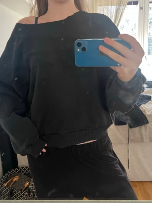 Svart oversized hoodie - Säljer en svart oversized hoodie med bred halsringning som kan bäras off-shoulder som jag har klippt själv 