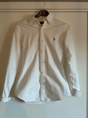 Raffe skjorta - En vit skjorta från Ralph Lauren. Najs till sommarn och passar sjukt bra till linnebrallor. Väl omhändertagen, skriv vid frågor!