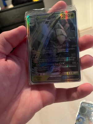Pokémonkort Golisopod GX holo - Säljer ett Pokémonkort av typen Golisopod GX med holografisk yta. Kortet har HP 210 och flera attacker som First Impression, Armor Press och Crossing Cut GX. Kortet är i plastficka och har en färgstark, glansig finish.